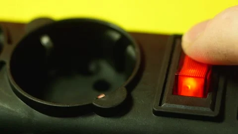 Close-up of a finger turns on the power button of a 220 volt surge protector. Po Vídeos de archivo 150949867