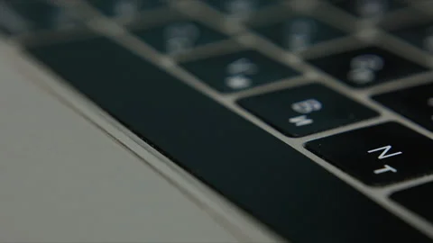 Close up of finger typing on laptop keyboard in modern digital workspace Stock Footage 340401137