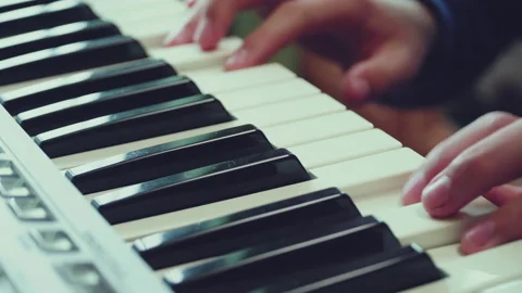 Close-up of fingers of a boy learning playing the piano. Video stock 154933338