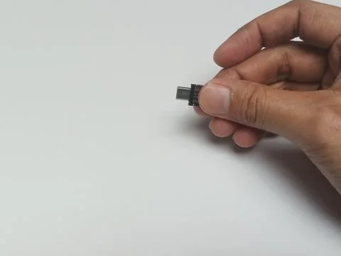 Close up of fingers holding tiny micro USB adapter plug Foto stock