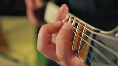 Close-up of the fingers of the left hand pressing strings of an electric guitar Video stock 316780396