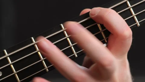 Close-up of fingers pressing strings on a bass guitar fretboard Stock Footage 301297765