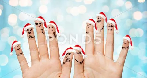 Close up of fingers with smiley in santa hats Stock Photos