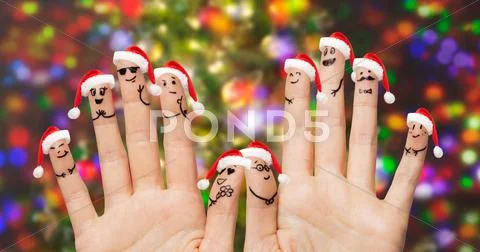 Close up of fingers with smiley in santa hats Stock Photos
