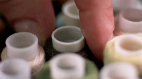 Close-up fingers take out a spool of thread from the box. Sewing Stock Footage 170369600