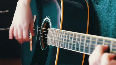 Close-up fingers touch the strings on the guitar Stock Footage