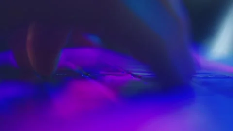 Close-up on fingers typing on a laptop keyboard with vibrant neon RGB light.. Stock Footage 337406100