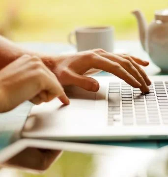 Close-Up of Fingers Typing on a Laptop Keyboard Outdoors Stock Photos