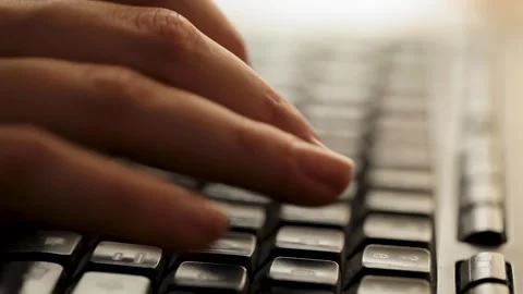 Close-up of fingers typing quickly on a backlit keyboard, focus on hands Stock Footage 276581014