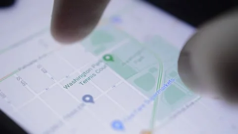 Close-up fingers using digital google gps software app on the smartphone. Vidéo 222744441