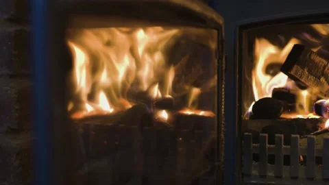 Close up of Fire burning in log burner with door open while slowly panning Video stock 142479783