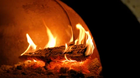 Close-up of a fire burning in a wood-burning stone stove. Pizza oven in the Stock Footage 264311142