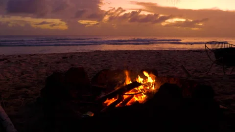 CLOSE UP: Fire burns on tropical white sand shore of Barbados on sunny evening Stock Footage 133046900
