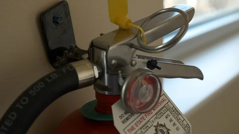 Close-up of fire extinguisher hanging on wall inside office building. Stock Footage 99426832
