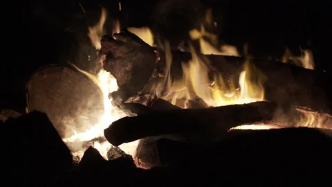 Close up of fire flames on logs slowly burning at night Stock Footage 122379866
