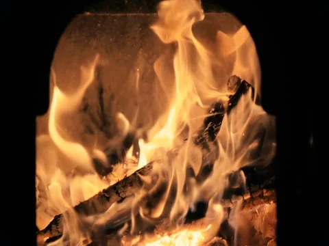 Close-up of a fire slowly eats wooden logs in the home fireplace in slow motion. Video stock 83732361