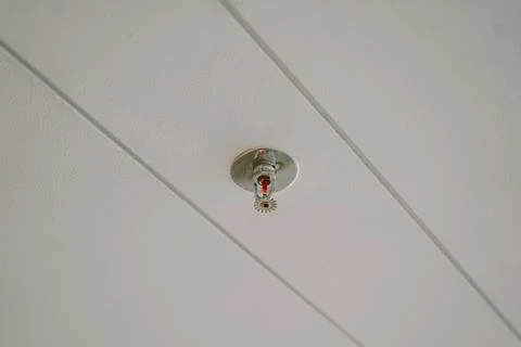 Close-up of a fire sprinkler installed on a ceiling, showcasing its design .. Stock Photos