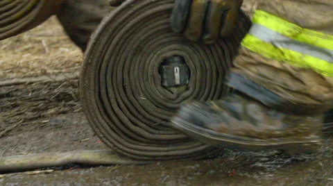 Close up on firefighter wrapping up a hose Stock Footage 61181291