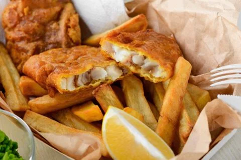 Close up on fish and chips. Squeeze lemon juice to add a nice taste Stock Photos