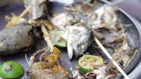 Close up of fish head, bones, and limes on a plate Stock Footage 78202617