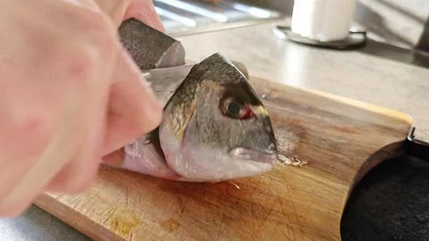Close up of a fish head separated during cutting on a wooden board. 動画素材 340926501