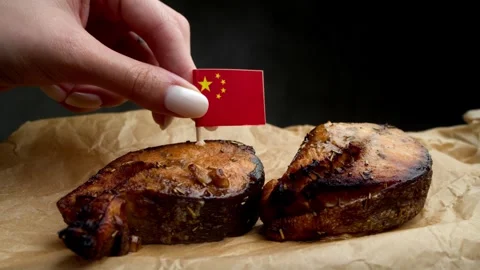 Close up of fish steak with Chinese flag, composition links dish with Pacific Stock Footage 323013019