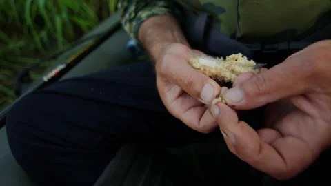 Close-up of a fisherman's hands stringing a bait on a hook before fishing Stock Footage 219776386