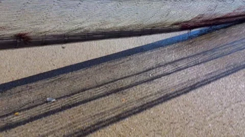 Close-up of a fishing net being pulled from the sea, in motion with its Stock Footage 250627087