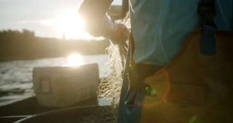 Close up of fishing net with sunrise lens flare, fisherman pulling net out o Stock Footage