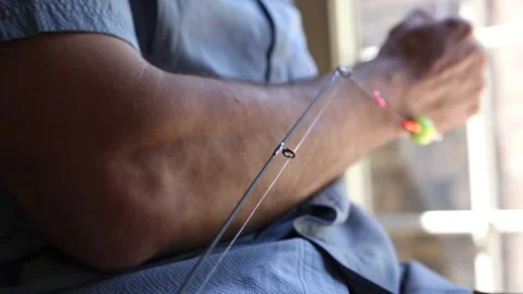Close up of fishing pole while man ties a hook on his line Vídeos de archivo 135615055