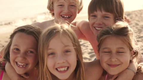 Close up of five children on beach facing camera and laughing. Vidéo 43673077