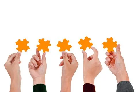 Close up of five hands holding orange jigsaw puzzle isolated on white backgro Stock Photos