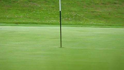 Close Up of a Flagstick Inserted into a Putting Green Hole Stock Footage 337637897