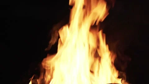 Close up of flames in a campfire during night while someone adds new logs Stock Footage 235153720