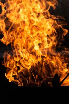 Close up of the flames of a small bonfire burning outdoors, campfire in summe Stock Photos