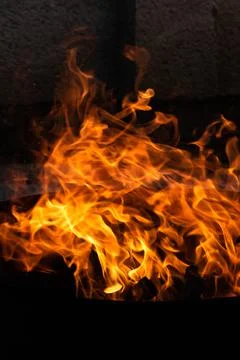 Close up of the flames of a small bonfire burning outdoors, campfire in summe Stock Photos