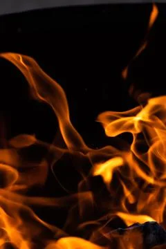 Close up of the flames of a small bonfire burning outdoors, campfire in summe Stock Photos