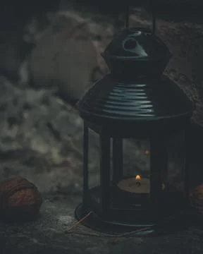 Close-up of a flashlight with a burning candle. Dark photo at dusk. Style of Stock Photos