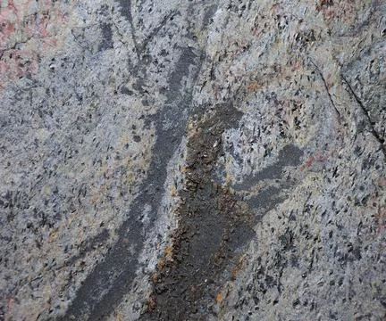 A close-up of a flat gray stone with a chipped surface and traces of rough pr Stock Photos