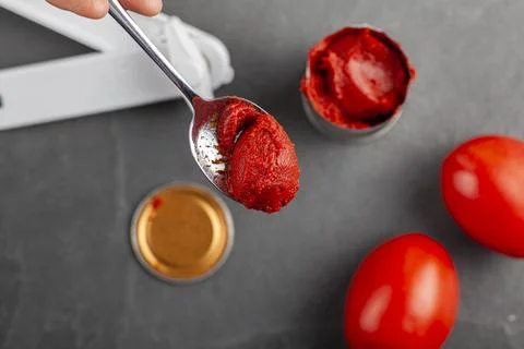 Close up flat lay image of a spoon with tomato paste in it. There is a bpa fr Stock Photos