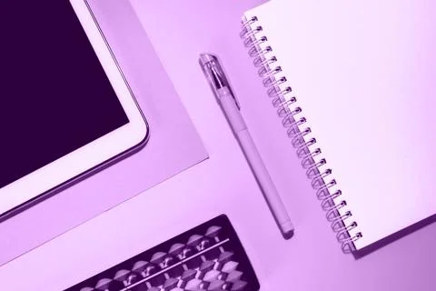 Close up flat lay with laptop, abacus, noteook and pen on purple background. Stock Photos