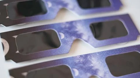 Close-up flat lay view of protective solar eclipse paper glasses featuring a Stock Photos