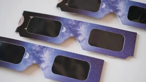 Close-up flat lay view of protective solar eclipse paper glasses featuring a Stock Photos