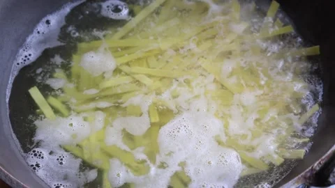 Close-up of flat noodles boiling in a karahi on a kitchen stove. Stock Footage 317867745