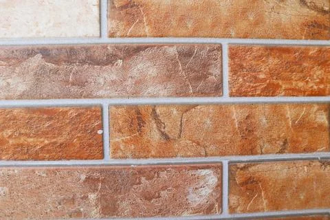 Close-up flat view of a textured orange and beige split-face decorative bri.. Stock Photos