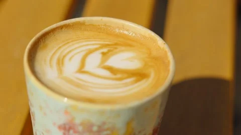 Close-up of Flat White with Artful Finish on Wooden Table Outside Видео 333799913