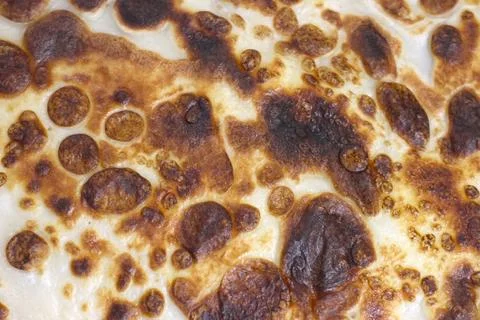 Close-up of a flatbread's surface showcasing a golden brown texture with bubb Foto stock
