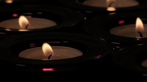 Close up flickering flame of tealight candle in purple holder Video stock 73954531