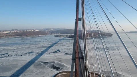 Close flight cables bridge Russky Island Vladivostok frozen ice road traffic Stock Footage 86502444