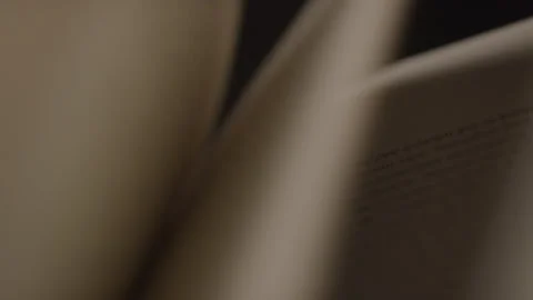 Close-up of Flipping Book Pages Under Studio Light with Black Backdrop Stock Footage 222008469